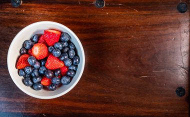 Çilek ve yaban mersini beyaz kase yemeye hazır