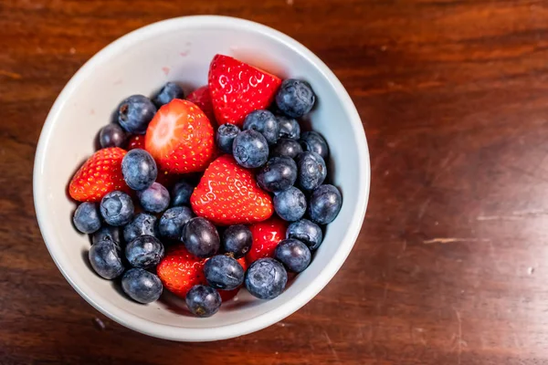 Çilek ve yaban mersini beyaz kase yemeye hazır