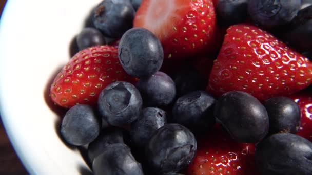 Strawberries and blueberries in white bowl ready to eat — Stock Video