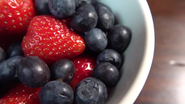 딸기와 블루베리를 먹을 준비가 된 흰색 그릇에 담습니다. — 비디오