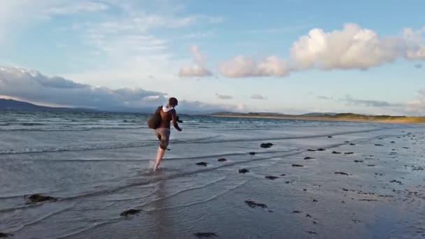 Senhora correndo pela praia durante o pôr do sol — Vídeo de Stock