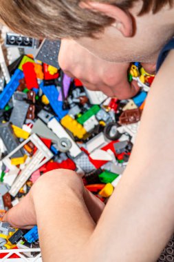 Yerde plastik inşaat oyuncakları ile oynayan çocuk.