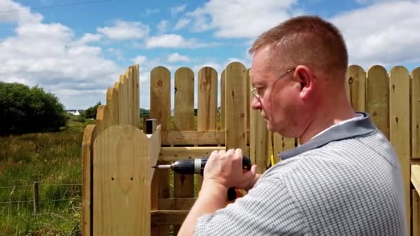 Бурение винта в деревянный забор — стоковое видео