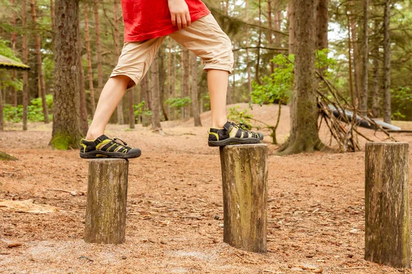 Niño balanceándose en los árboles - saltando de uno a otro — Foto de Stock