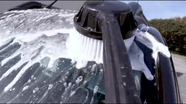 Man använder högtryckstvätt och borste för att rengöra bilen och hjulen — Stockvideo