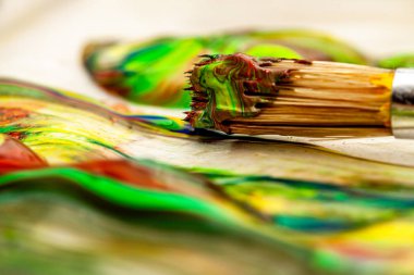 Fırça ve tencerede sıvı sanatçı renklerinin yakınkapatılması