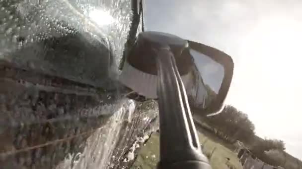 Homem usando arruela de alta pressão e escova para limpar carro e rodas — Vídeo de Stock