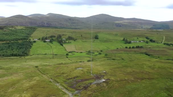 Вид с воздуха на вышку передатчика на сельскохозяйственном поле в ирландском нагорье в графстве Донегал — стоковое видео