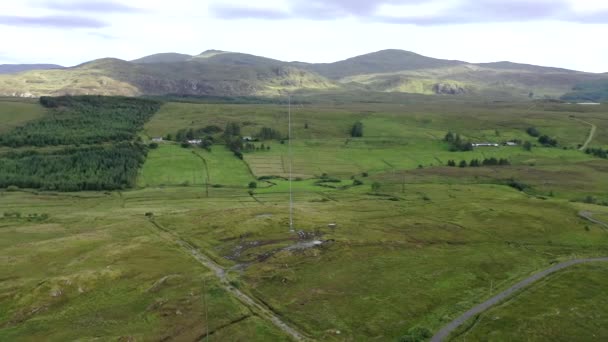 Vista aérea da torre do transmissor em um campo agrícola nas terras altas irlandesas por Glenties no condado de Donegal — Vídeo de Stock