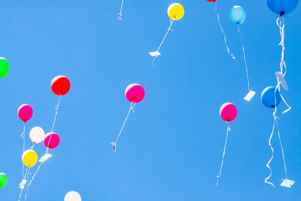 Colorful ballons with letters flying in the blue sky