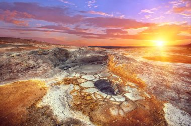 Sunset over mudpot field in Iceland clipart