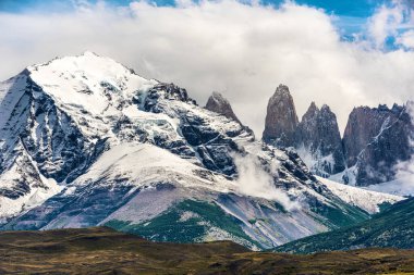 Torres del Paine tepeleri bulutlardan geliyor. Torres del Paine Ulusal Parkı, Şili
