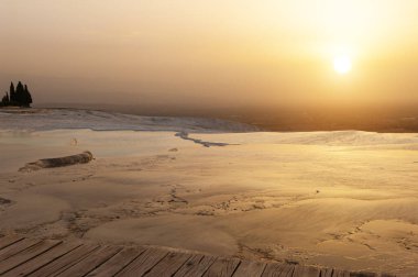 Pamukkale, Türkiye 'deki travertin terasları ve havuzların üzerinde güzel canlı gün batımı