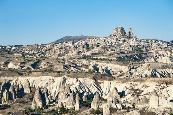 Ancient town and a castle of Uchisar dug from a mountains after sunrise, Cappadocia, Turkey