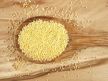 Tahta kaşık ahşap bir masa üzerinde darı