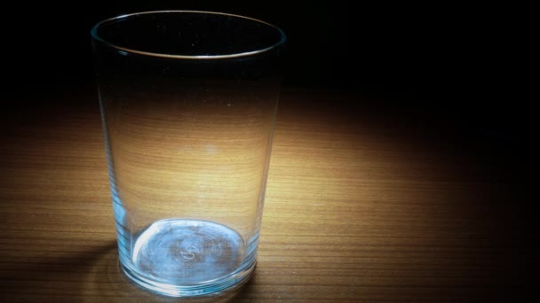Agua Vertiendo Vidrio Transparente Sobre Fondo Oscuro — Vídeo de stock