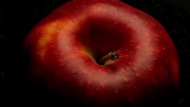 Koyu arkaplanda kırmızı elma döner tablada hareket ediyor