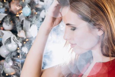 Noel. Noel ağacı kırmızı elbiseli güzel gülümseyen kadın Elegant arka plan ışıklar. Yeni Yılınız Kutlu Olsun.