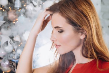 Noel. Noel ağacı kırmızı elbiseli güzel gülümseyen kadın Elegant arka plan ışıklar. Yeni Yılınız Kutlu Olsun.