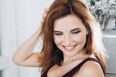 Ritchen güzel gülümseyen kadın. Tırnaklar manikür. Makyaj. Kırmızı uzun saç stili. Zarif Bayan siyah gövde frige