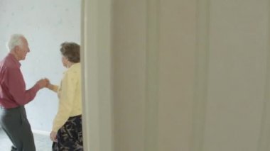 Onların oturma odasında jive dans kalbinde kıdemli beyaz aktif genç çift