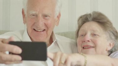 Mutlu kıdemli beyaz çift alarak selfies bir smartphone cep telefonu ile