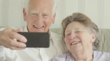 Mutlu kıdemli beyaz çift alarak selfies bir smartphone cep telefonu ile