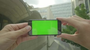 Ofis dışında Chroma anahtar yeşil ekran smartphone kullanarak rahatlatıcı bir beyaz adamın kişisel bakış açısı