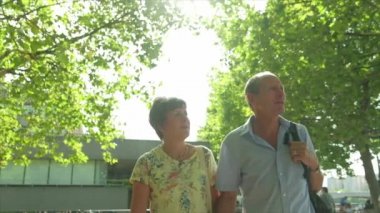 Ağır çekim sabit cam görünümü Londra arkadan aydınlatmalı tarafından Paz yürüyüş bir etkin üst düzey beyaz turist çiftin