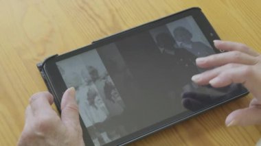 Beyaz kadın kendini bir tablet bilgisayarda eski fotoğrafları bakarak kıdemli