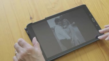 Beyaz kadın kendini bir tablet bilgisayarda eski fotoğrafları bakarak kıdemli 
