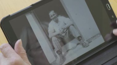 Beyaz kadın kendini bir tablet bilgisayarda eski fotoğrafları bakarak kıdemli 