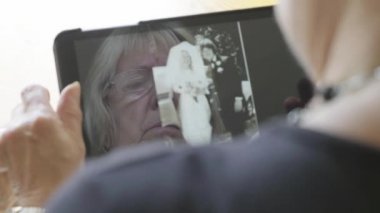 Beyaz kadın kendini bir tablet bilgisayarda eski fotoğrafları bakarak kıdemli