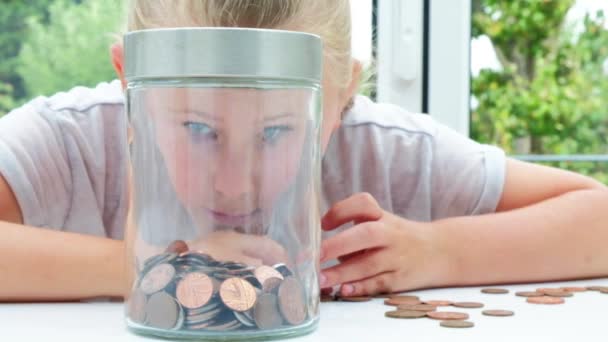 Pre Teen Caucasian Girl Putting Coins Jar — Stock Video