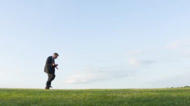 Bir tepe üzerinde hava gitar çalmak mutlu kaygısız orta yaşlı beyaz iş adamı