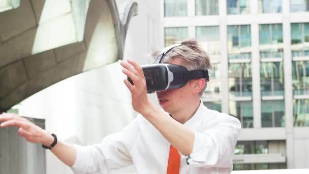 中年白种商人穿着虚拟现实护目镜外面的办公室玩身临其境360视频游戏 — 图库视频影像