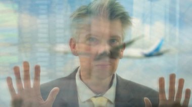 Beyaz bir işadamı bir Havaalanı pencereden dışarı bakıyor yansıması 