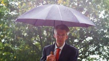 Beyaz işadamı Sağanak yağmurda bir şemsiye altında barınma