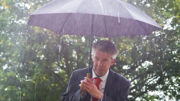 Kaukázusi Üzletember Menedéket Alatt Egy Esernyő Zuhogó Esőben — Stock videók