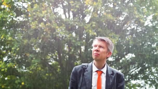 雨の中傘もびしょ濡れになった白人実業家キャッチ — ストック動画