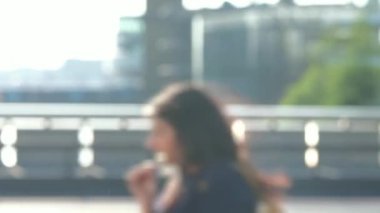 Yayalar Londra Köprüsü arkadan aydınlatmalı Londra Köprüsü üzerinde güneşin karşı bir acele saatte defocussed. Rush hour trafik sıkışıklığı yollarda ve toplu taşımayla kalabalık en yüksek olduğu gün bir parçasıdır. 