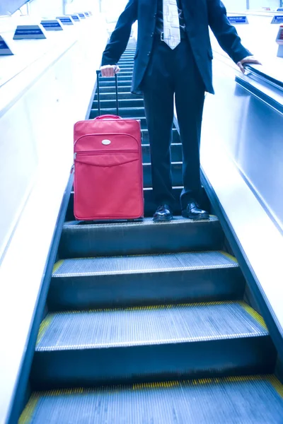 Geschäftsmann fährt Rolltreppe hinunter — Stockfoto