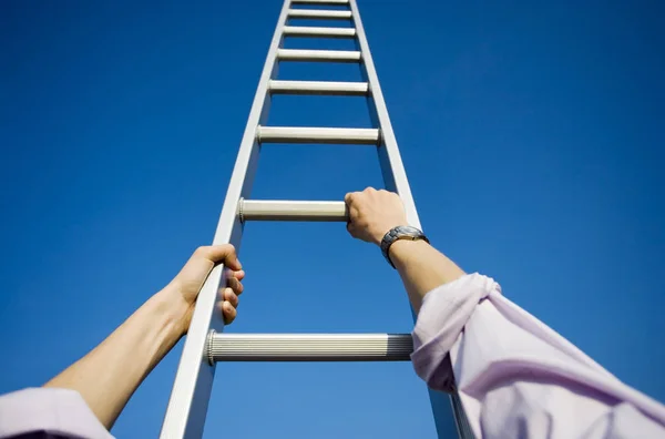 Hombre de negocios escalando una escalera Imagen de stock