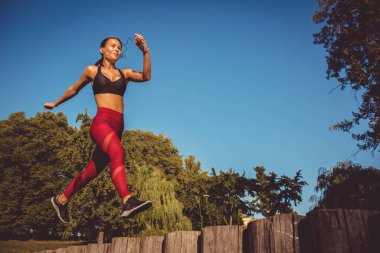 kadın kırmızı tozluk ve koşma ve atlama park, düşük açılı görünüş sportif üst