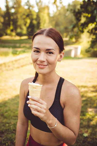 beautiful brunette woman with ice cream in park