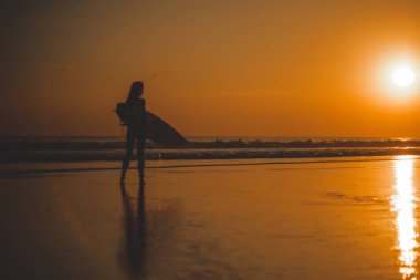 sörfçü kadın siluet denizde sörf, su günbatımı yansıma ile 
