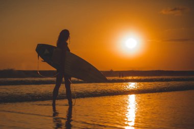 denizde surfboard ile duran kadın tam uzunlukta