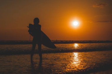 denizde surfboard ile duran kadın tam uzunlukta