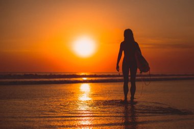 aktif sörfçü kadın siluet denizde sörf, su günbatımı yansıma ile 