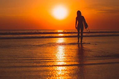 aktif sörfçü kadın siluet denizde sörf, su günbatımı yansıma ile 